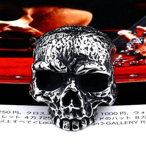 Vintage gothic schedelring van roestvrij staal, vooraanzicht op rood fluwelen achtergrond
