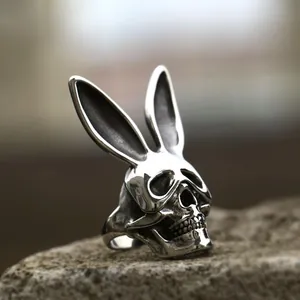 Macro shot of vintage silver skull rabbit ring on a textured dark stone background