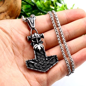 Dettaglio del ciondolo vichingo Mjölnir con testa di Thor e motivi a nodi celtici