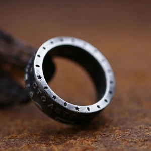 Macro shot of retro stainless steel ring featuring brushed texture and engraved stars