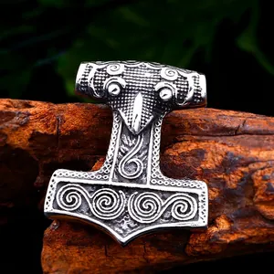Vintage stainless steel Mjölnir pendant with Celtic engravings on rustic wood background