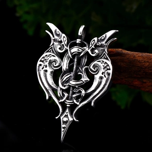 Vintage stainless steel double raven pendant with viking aesthetic on dark wood background