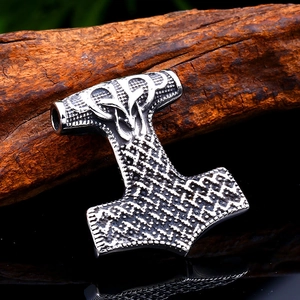 Macro view of vintage stainless steel Mjolnir pendant with Viking raven engravings
