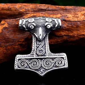 Detail of vintage stainless steel Mjölnir pendant with Nordic raven and spiral patterns