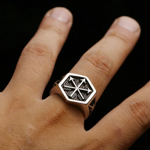 Macro detail of men's stainless steel arrow ring with vintage oxidized hexagon face