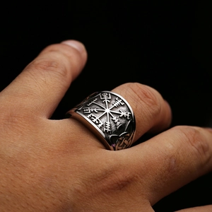 Macro detail of vintage Viking Vegvisir compass ring with Norse runes and aged steel finish