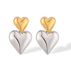 Detailed close-up of double-layered heart earrings in polished gold and silver finish