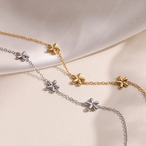 Elegant 18K gold and silver stainless steel flower bracelets on white silk background