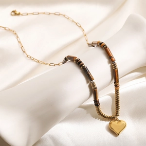 Collier pendentif coeur doré vintage avec perles oeil de tigre sur fond en soie blanche