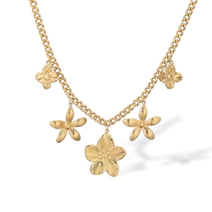 Nahaufnahme von vergoldeten Blumenanhängern an einer groben Gliederkette aus Edelstahl