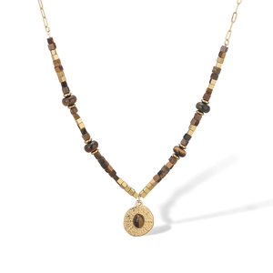 Détail du collier en acier inoxydable doré avec pendentif oeil de tigre et texture martelée