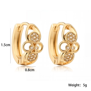 Détail des boucles d'oreilles créoles plaquées or 18K avec motifs ajourés et oxydes