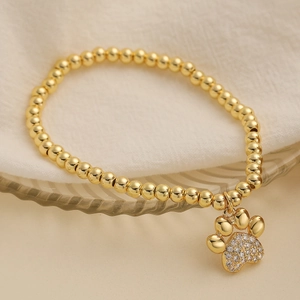 Elegante 18K vergulde kralenarmband met fonkelende pootafdruk hanger op glaswerk