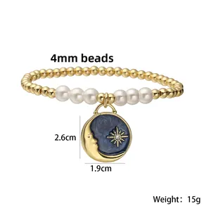 Detail view of 18K gold plated beaded bracelet with blue enamel moon and star pendant