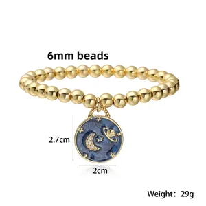 Detailed view of 6mm gold bead bracelet with blue enamel moon and stars pendant