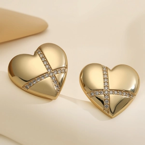 Elegant gold heart stud earrings with sparkling cross-shaped pavé zircon stones on white base