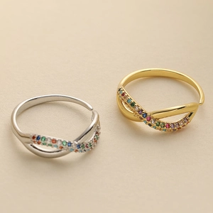 Intertwined gold and silver rings set with colorful zircons in a diagonal layout