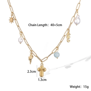 Detailed view of 18K gold plated sun cross necklace with sea horse and pearl charms