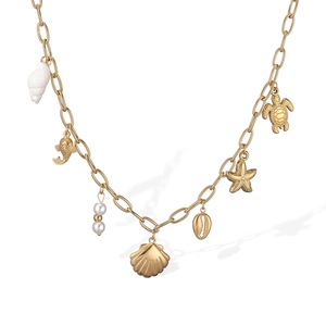 Detail of 18K gold plated shell necklace featuring charms like starfish, sea turtle and pearls