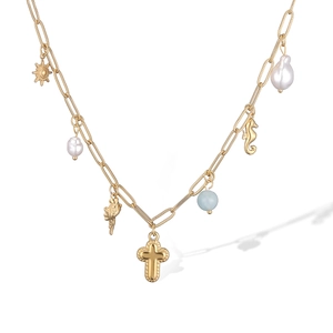 Detail of vintage 18K gold plated necklace with sun, cross, pearl, and seahorse charms