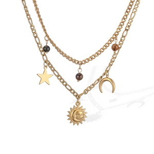 Detailed macro view of 18K gold sun moon face pendant and celestial beaded chain charms
