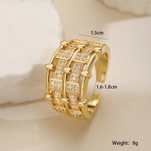 Vue macro d'une bague large plaquée or avec incrustations de zircon et texture grille