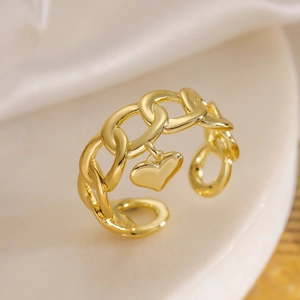 Détail d'une bague chaîne dorée avec pendentif coeur poli sur socle d'exposition
