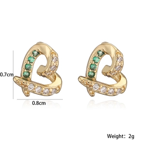 Detailed macro view of gold-plated heart earrings with green and clear zircon stones