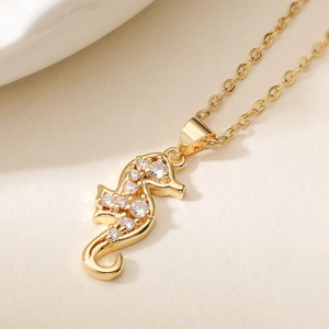 Collier avec pendentif hippocampe doré orné de zircons brillants sur une chaîne fine