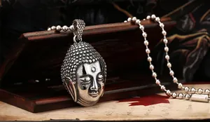 Gros plan détaillé du pendentif Bouddha rétro en acier sur un fond de lettre vintage