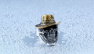 Macro shot of punk style stainless steel skull ring with golden cowboy hat detail