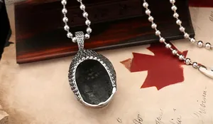 Macro du pendentif Bouddha argenté rétro avec textures et collier à chaîne à billes