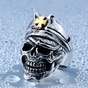Vintage punk skull ring with golden cross on hat against water splash background