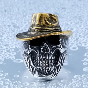 Vintage stainless steel cowboy skull ring with bronze hat on a wet reflective background