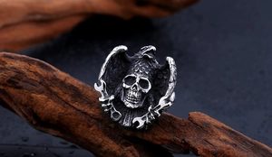 Macro view of stainless steel skull ring with eagle wings and crossed wrench detail