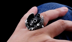 Macro detail of hand-carved stainless steel biker ring featuring skull and eagle wings