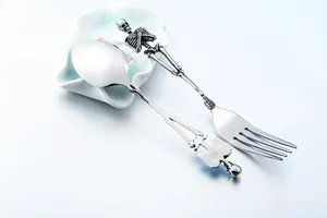 Macro detail of skull skeleton handle on silver stainless steel gothic cutlery set