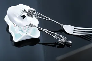 Gothic skull cutlery set featuring bone-shaped handles and intricate stainless steel craftsmanship