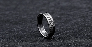 Macro detail of vintage etched geometric patterns on black stainless steel ring band