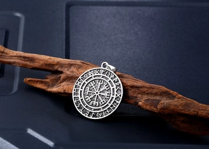 Detailed side view of vintage Viking Vegvisir compass pendant with Nordic runes on wood