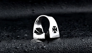 Macro view of vintage stainless steel biker ring featuring a cutout iron cross motif