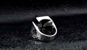Macro shot of retro stainless steel men's ring featuring Maltese cross design on black leather