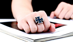 Detailed view of men's vintage stainless steel ring with black enamel cross on hand