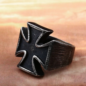 Close-up of vintage stainless steel iron cross ring with black oxidized finish and brushed metal