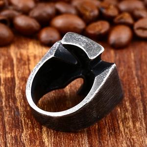 Vintage oxidized stainless steel iron cross ring for men on rustic wood background