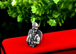 Macro shot of a gothic bishop skull ring with inverted cross on a red velvet stand