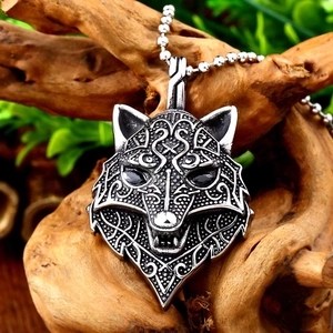 Macro view of Viking wolf pendant with Norse runes and vintage silver finish on wood