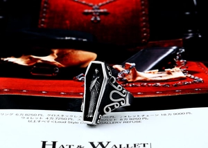 Macro detail of Gothic coffin ring with engraved figure on red velvet background