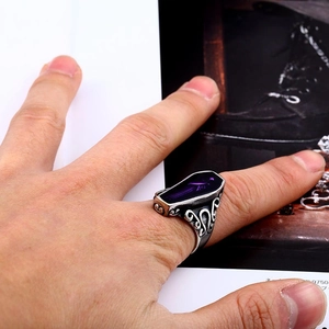 Macro detail of Gothic vampire coffin ring with purple gemstone and filigree engraving