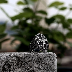 Men's vintage viking skull ring with ornate vine carvings on grey stone background